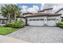 Two-story house with tile roof, three-car garage, and landscaped yard at 6648 Sunset Vista Way, Land O Lakes, FL 34637