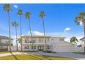 Two-story waterfront home with palm trees and a paved driveway at 7810 10Th S Ave, St Petersburg, FL 33707