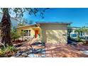 House exterior showcasing a yellow stucco finish and a side yard with stone pathway at 830 S Davis Blvd, Tampa, FL 33606