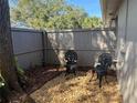 Private, fenced patio area with decorative gravel, mulch and two decorative cast-iron chairs at 8608 Lake Isle Dr # 0, Temple Terrace, FL 33637