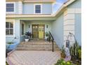 Inviting front entrance with double doors and stone steps, complemented by lush greenery and decorative accents at 952 Symphony Isles Blvd, Apollo Beach, FL 33572