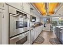 Well-equipped kitchen featuring stainless steel appliances, custom cabinetry, and stylish wood flooring at 952 Symphony Isles Blvd, Apollo Beach, FL 33572