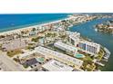 Aerial view of coastal community, showing beach, water, and multiple buildings at 9715 Harrell Ave # 25, Treasure Island, FL 33706