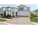 Two-story house, white exterior, paver driveway and landscaping at 10406 Longmeadow Ave, Parrish, FL 34219