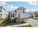 Two-story house with white exterior, paver driveway, landscaping, and two-car garage at 10406 Longmeadow Ave, Parrish, FL 34219