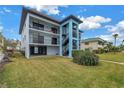 Two-story condo building, featuring a light blue exterior, and lush landscaping at 12080 Capri S Cir # 102, Treasure Island, FL 33706