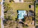 Aerial view of a property showcasing a well-maintained lawn, mature trees, and a cozy single-story home at 13050 110Th Ave, Largo, FL 33774