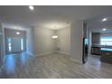 Open living area with grey tile floors and modern lighting at 13146 Kent Bradley St, Dade City, FL 33525