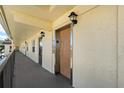 Exterior hallway showing a wooden elevator door, traditional lighting fixtures and dark handrails at 1450 Heather Ridge Blvd # 305, Dunedin, FL 34698