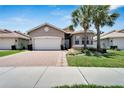 House exterior showcasing a two-car garage and manicured lawn at 16028 Golden Lakes Dr, Wimauma, FL 33598