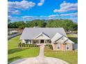 Expansive property featuring a well-maintained lawn, circular driveway, and metal roof at 1702 W Knights Griffin Rd, Plant City, FL 33565