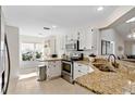 Bright kitchen featuring white cabinets, granite countertops, and stainless steel appliances and a sunny breakfast nook at 18529 Otterwood Ave, Tampa, FL 33647