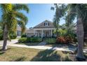 Tan house with palm trees and a well-manicured lawn, inviting curb appeal at 404 Manns Harbor Dr, Apollo Beach, FL 33572