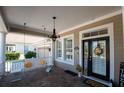 Charming front porch with a porch swing and sunflowers, welcoming entrance at 404 Manns Harbor Dr, Apollo Beach, FL 33572