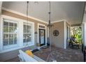 Relaxing front porch featuring a swing and hanging light fixture, inviting atmosphere at 404 Manns Harbor Dr, Apollo Beach, FL 33572