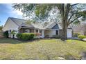 House exterior with mature tree and landscaping at 4804 Foxshire Cir, Tampa, FL 33624