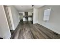 Open living room and kitchen with gray wood-look flooring at 502 E Cluster Ave, Tampa, FL 33604