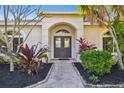 Double dark-brown doors and a brick pathway leading to the home's entrance at 714 Hidden Lake Dr, Tarpon Springs, FL 34689