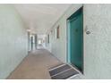 Condo hallway featuring a ramp that leads to a green-painted door with the number 215 at 801 83Rd N Ave # 215, St Petersburg, FL 33702