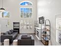 Bright living room with high ceilings, large windows, modern furnishings, and a decorative fireplace at 8619 Foxtail Ct, Tampa, FL 33647