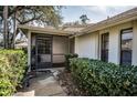 Front entry with screened porch and well-manicured hedges at 9204 Golf View Dr, New Port Richey, FL 34655