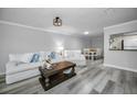 Bright living room with white couch, coffee table, and wood-look floors at 9204 Golf View Dr, New Port Richey, FL 34655