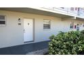 Condo entrance featuring unit 102, a security light, a decorative door knocker, and attractive shrubbery at 9940 47Th N Ave # 102-C, St Petersburg, FL 33708