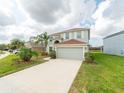 Two-story house with light gray siding, red door, and a large driveway at 11601 Mansfield Point Dr, Riverview, FL 33569