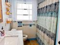 Cozy bathroom featuring tiled walls, wooden shelves, and a shower with a decorative curtain at 12361 114Th St, Largo, FL 33778