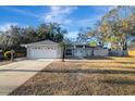 Gray house with white garage door and walkway leading to the entrance at 2733 Glenview Dr, Land O Lakes, FL 34639