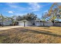 Single-story house with gray exterior, white garage door, and a grassy yard at 2733 Glenview Dr, Land O Lakes, FL 34639