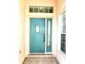 Teal front door with glass panels and sidelights at 286 Royal Palm Way, Spring Hill, FL 34608