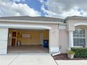 View of an open garage with storage, an interior door and access to the house, and an outside recycling bin at 286 Royal Palm Way, Spring Hill, FL 34608