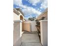 Exterior side view of a home showcasing a white fence and a walkway at 286 Royal Palm Way, Spring Hill, FL 34608