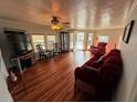 Bright living room with wood floors, multiple seating areas, and a large window at 3301 Alt 19 # 126, Palm Harbor, FL 34683