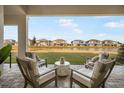 Relaxing patio with seating area overlooking a lake at 33843 Galley Way, Wesley Chapel, FL 33543