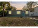 Front view of a charming gray house at dusk with lights on at 4724 W Lawn Ave, Tampa, FL 33611