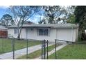 White ranch house with a chain link fence and grassy yard at 4940 Rosedale Ln, Holiday, FL 34690