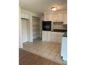 Galley kitchen with white cabinets, tile floors and built-in oven at 4940 Rosedale Ln, Holiday, FL 34690