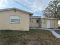 Rear view of the house showcasing a small patio and detached shed at 5163 Jasmine Cir, St Petersburg, FL 33714