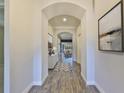 Bright entryway with wood-look tile flooring and arched doorways at 6321 Voyagers Pl, Apollo Beach, FL 33572