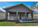 Charming single-story home featuring a cozy front porch, fresh landscaping, and neutral gray exterior paint at 8716 N Brooks St, Tampa, FL 33604