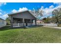 Inviting single-story home showcasing a well-manicured lawn and a classic porch at 8716 N Brooks St, Tampa, FL 33604