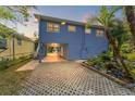 Charming blue two-story home with a patterned driveway and lush landscaping at 906 W Henry Ave, Tampa, FL 33604