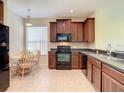 Spacious kitchen featuring dark wood cabinets and black appliances at 929 Windton Oak Dr, Ruskin, FL 33570