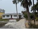 Quaint single-story house with a palm tree-lined driveway at 944 Bruce Ave, Clearwater Beach, FL 33767