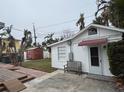 Small white guest house with red awning and wooden bench at 944 Bruce Ave, Clearwater Beach, FL 33767