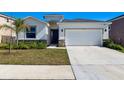 Inviting home showcasing a two-car garage, stone accents, and lush landscaping at 9804 Rowing Dale Bnd, Wesley Chapel, FL 33545