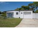 White mid-century modern home with a single car garage and fenced yard at 5601 9Th N Ave, St Petersburg, FL 33710