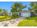 Front view of a light blue house with a white garage door at 10 N Mercury Ave, Clearwater, FL 33765